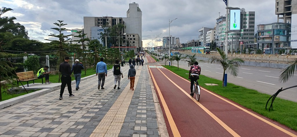 Pedestrians and a cyclist using the Megenagna Ayat transport corridor in Addis Ababa